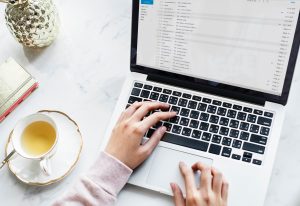 Image of a laptop with someone reading emails