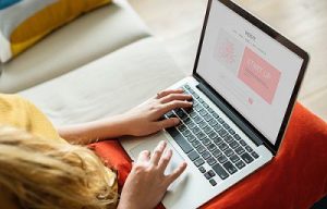 Woman in front of a laptop creating a startup website