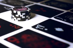 Image of poker chips on a table with cards